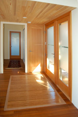 New entry with cedar ceiling and floor. Frosted glass doors bring in natural light while maintaining privacy